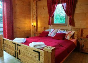 Schlafzimmer mit einem großen Holzbett mit roter Bettwäsche in der Unterkunft Bukowiańska Ostoja - 60m od Wyciągów- Sauna Balia i Jacuzzi w Ofercie in Bukowina Tatrzańska
