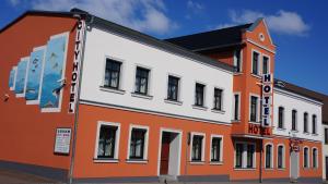 ein orangefarbenes und weißes Gebäude auf einer Straße in der Unterkunft City-Hotel-Wolgast in Wolgast