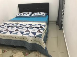 ein Schlafzimmer mit einem Bett mit einer Decke und Kissen in der Unterkunft SINGGAH Putrajaya - 3 Bedrooms with Pool and KL View in Putrajaya