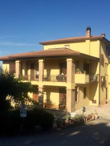 een groot geel gebouw met een veranda en een balkon bij Il girasole in Castel Ritaldi