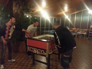 Un groupe d'hommes autour d'une table avec un jeu dans l'établissement Albergo Pizzeria Sole, à San Giovanni Lupatoto