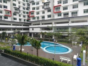 um grande edifício de apartamentos com uma piscina em frente em The Khailily's Guest em Sepang