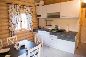 a kitchen with white cabinets and a table in a room at Cicha Polana in Szczyrk