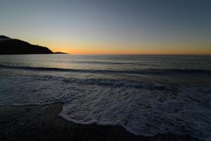 una playa con puesta de sol sobre el océano en Bahía Tropical, en Almuñécar