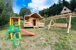 a playground with a slide and a log cabin at Cicha Polana in Szczyrk