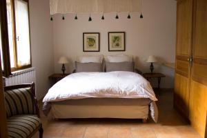 een slaapkamer met een wit bed met twee tafels en twee lampen bij Les Clèdes du Mazel in Banne +44 foto's