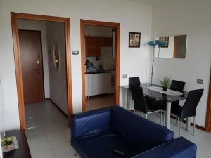 Bisceglie Aparthotel في ميلانو: غرفة معيشة مع أريكة زرقاء وطاولة