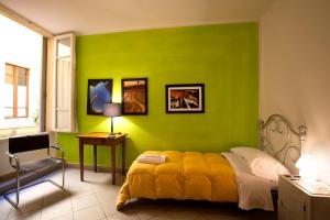 um quarto com uma parede verde e uma cama em B&B Le Lupe em Siena