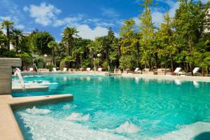 uma piscina com água azul num resort em Abano Grand Hotel em Abano Terme