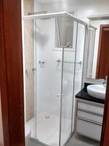 y baño con ducha acristalada y lavamanos. en Mahalo Happy Apartment, en Florianópolis