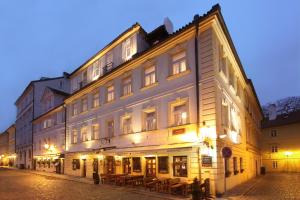 a large white building on a street at night at Hotel At the Golden Scissors in Prague