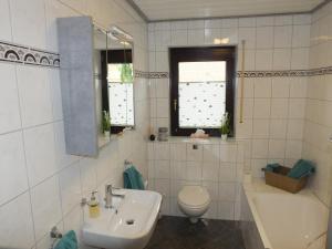 a bathroom with a sink and a toilet and a tub at Ferienwohnung Baumberge in Nottuln