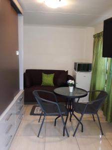 sala de estar con mesa y sofá en Thula Du Estate - one bed apartment, en Mbabane