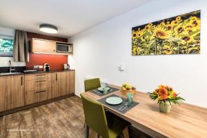 a kitchen with a wooden table with chairs and a counter at Übernachten in der Tenne in Nürnberg +15 photos