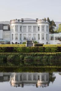 een wit gebouw naast een waterlichaam bij Hotel Minella & Leisure Centre in Clonmel