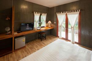 a living room with a desk with a computer and windows at Chiang Dao Reset in Chiang Dao +43 photos