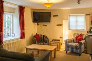 a living room with two chairs and a flat screen tv at The Old Nag's Head in Edale