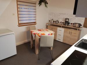 uma pequena cozinha com mesa e cadeiras em Ferienwohnung Müller em Steinach