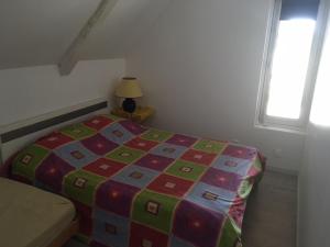 a bedroom with a bed with a colorful blanket at LE GRAND PARADIS in Daumeray