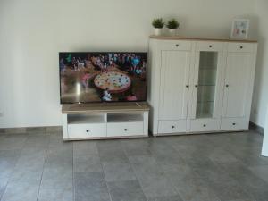 a living room with a flat screen tv and white cabinets at Ferienhaus Landblick in Geldern