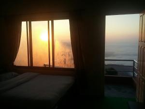ポカラにあるHimalayan crown lodgeのベッド1台、景色を望む窓が備わる客室です。