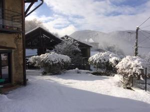 a snow covered yard with trees and a building at Grand studio au calme à la campagne, tout prés de la ville !!! in Venon