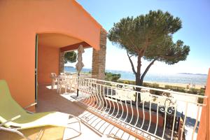 Un balcón con sillas y vistas al océano. en Villa L'ensoleillade, en La Londe-les-Maures