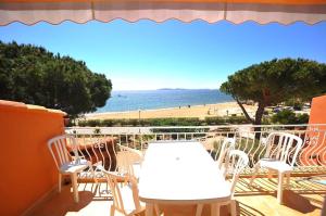 d'un balcon avec une table et des chaises donnant sur l'océan. dans l'établissement Villa L'ensoleillade, à La Londe-les-Maures