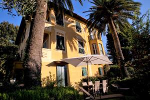 a yellow building with a tree and an umbrella at Villa Margherita in Levanto