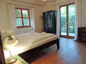 a bedroom with a bed with a lamp and windows at Haus Katha Koserow in Ostseebad Koserow