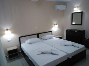 a bedroom with two beds with white sheets and pillows at Zante Yliessa in Vasilikos