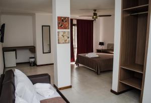 a hotel room with a bed and a living room at Rancho Grande Hotel in Villa General Belgrano