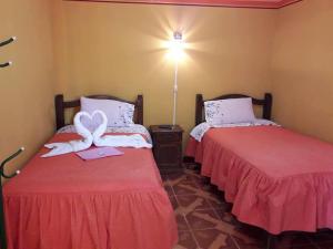 dos camas sentadas una al lado de la otra en una habitación en Hostal "La Roca" Uyuni, en Uyuni