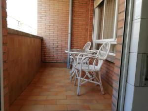 eine Terrasse mit Stühlen, einem Tisch und einem Fenster in der Unterkunft León Arena in León