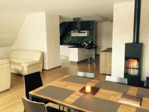 ein Wohnzimmer mit einem Esstisch und einer Küche in der Unterkunft Meublés de Tourisme Heidelbeere in Dambach