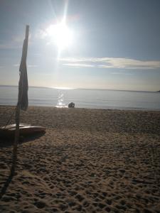 a beach with an umbrella on the sand at Rainbow Tioman Cottage in Kampong Juara