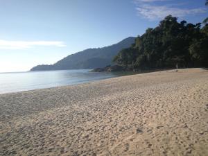 a sandy beach with a view of the ocean at Rainbow Tioman Cottage in Kampong Juara