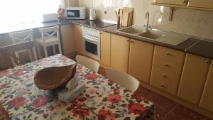 a small kitchen with a table and a sink at Casa Sinclair in El Colmenar