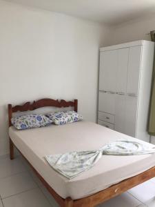 a bedroom with a bed and a white cabinet at Casa na Vila do Chicão in Aracaju