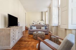 ポルトにあるFAISAMA • Porto Apartmentsのリビングルーム(ソファ、テレビ付)