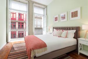 ポルトにあるFAISAMA • Porto Apartmentsのベッドルーム1室(大型ベッド1台、窓2つ付)