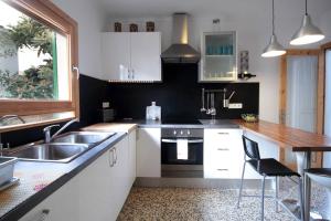Una cocina con gabinetes blancos y un fregadero. en La Casita Delfin Azul, en Sa Ràpita