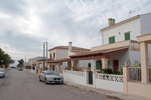 Un coche aparcado al costado de una calle junto a casas. en La Casita Delfin Azul, en Sa Ràpita
