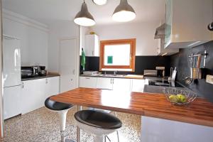 cocina con mesa de madera y 2 taburetes en La Casita Delfin Azul, en Sa Ràpita 21 fotos más
