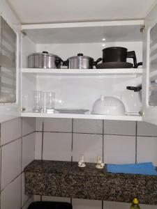 a kitchen with two pots and pans on a shelf at Edf. Iracema Costa in Recife