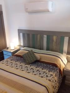 a bedroom with a bed with a striped headboard at Visión ESCAPE Piriápolis in Piriápolis +67 photos