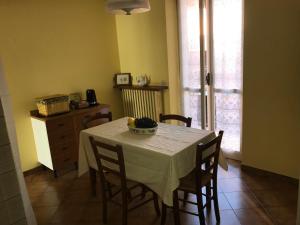 un comedor con una mesa con sillas y un tocador en Bed & Roses “Gege”, en La Morra