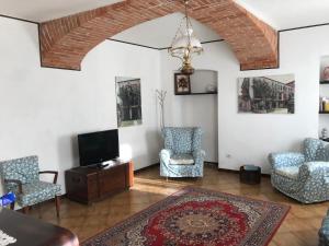 a living room with chairs and a flat screen tv at Bed & Roses “Gege” in La Morra