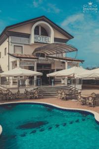 a hotel with a pool and tables and umbrellas at Hotel Insonnia in Agropoli