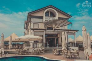 a hotel with a pool and tables and umbrellas at Hotel Insonnia in Agropoli